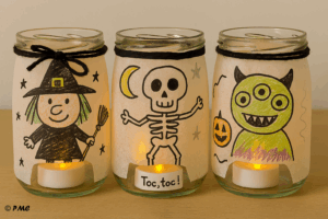 Trois lanternes Halloween décorées par des enfants avec des personnages : sorcière, squelette et monstre à trois yeux