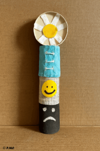 Trois tronçons de rouleaux de papier toilette alignés verticalement sur du carton.