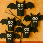 Chauves-souris d’Halloween fabriquées avec des rouleaux de papier toilette, décorées avec des capes, des chapeaux et des paillettes, suspendues à une branche