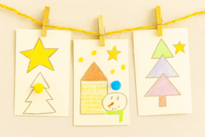 Guirlande de cartes de Noël enfantines suspendues à un fil doré avec des pinces