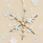 Flocon suspendu fait main par un enfant avec bâtonnets noués, papier aluminium, perles et sucre