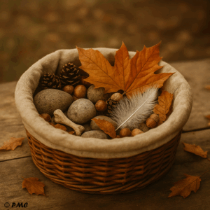 Panier sensoriel d’automne rempli de feuilles orangées, galets, plumes, glands et pommes de pin sur fond en bois rustique.