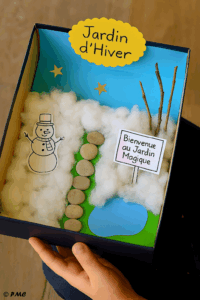 Version hivernale du jardin des fées avec coton pour la neige, étoiles dorées, bonhomme de neige et pancarte magique.