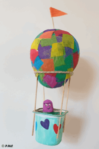 Montgolfière artisanale colorée fabriquée par un enfant avec des matériaux recyclés