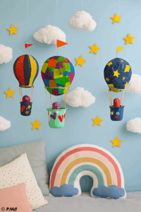 Montgolfières artisanales colorées suspendues dans une chambre d’enfant, entourées de nuages en coton et d’étoiles en papier