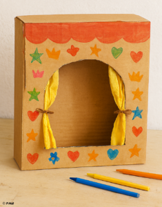 théâtre en carton décoré, avec rideaux dorés, frise rouge et marionnettes représentant différentes émotions.